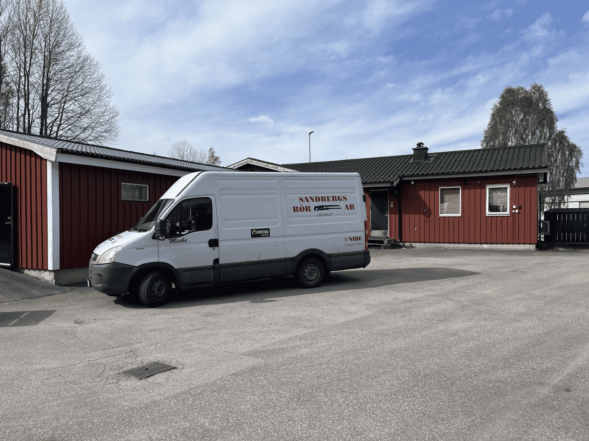 Sandbergs Rörs servicebil parkerad utanför butiks- och förrådsbyggnaden.